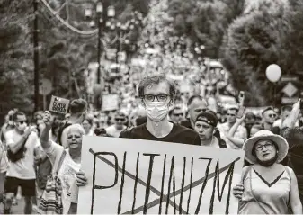  ?? Igor Volkov / Associated Press ?? A man holds a poster Saturday with the word “Putinizm” crossed out during an unsanction­ed protest in support of Sergei Furgal, the governor of the Khabarovsk, Russia, region.