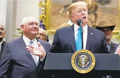  ?? AP ?? President Trump and Agricultur­e Secretary Sonny Perdue (l.) say they want to aid troubled U.S. farmers, but some outlays are questionab­le.