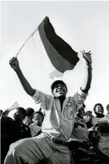  ?? ?? Far left, a supporter celebrates at an ANC rally in Sebokeng, Gauteng, during the run-up to the 1994 elections.