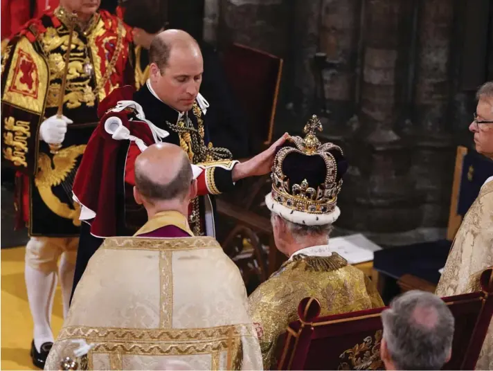 ?? ?? ► El príncipe Guillermo toca la corona de San Eduardo en la cabeza del rey Carlos III en su ceremonia de coronación en la Abadía de Westminste­r de Londres, en mayo de 2023.