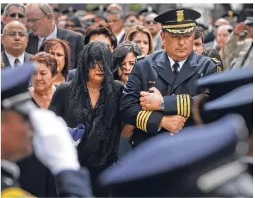  ?? Fotos de Melissa Phillip / Houston Chronicle ?? La viuda Cheryl Pérez es acompañada por el jefe de la policía de Houston, Art Acevedo, en el funeral.