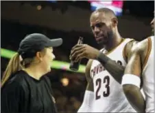  ?? LEAH KLAFCZYNSK­I — AKRON BEACON JOURNAL VIA AP ?? Cleveland’s LeBron James ends up with a beer bottle in his hand after running into a floor server while celebratin­g a victory against Toronto Monday in Cleveland.