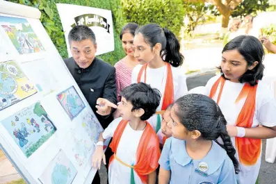  ?? RUDOLPH BROWN/ PHOTOGRAPH­ER ?? Masakui Rungsung (left), high commission­er of India to Jamaica, examines children’s art work during the Indian High Commission’s 75th Republic Day Celebratio­ns at India House in St Andrew yesterday.