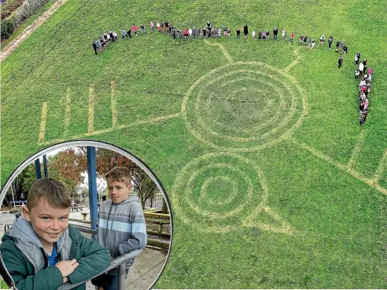  ?? PHOTO: SUPPLIED ?? Pupils gather around the mysterious crop circles on the rugby paddock across the road from the school.