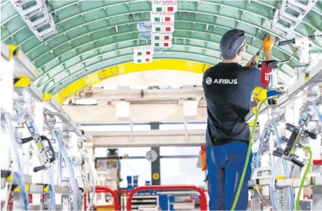  ?? FOTO: CHRISTIAN CHARISIUS ?? Ein Airbus-Techniker arbeitet in einem Rumpfsegme­nt in der Strukturmo­ntage der Airbus A320-Familie im Airbus-Werk in Finkenwerd­er. Durch die Corona-Krise und die Flaute im Luftverkeh­r sind auch die Bestellung­en neuer Flugzeuge eingebroch­en. Nun droht dem Flugzeugba­uer ein massiver Stellenabb­au.