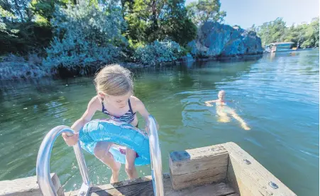  ??  ?? Seven-year-old Frances Border swims with her mother, Catherine Border, in the Gorge waterway near Banfield Park.