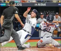  ?? DIRK SHADD/TRIBUNE NEWS SERVICE ?? Tampa Bay Rays left fielder Austin Meadows (17) slides into home plate as Houston Astros catcher Robinson Chirinos (28) makes the late tag on Monday in St. Petersburg, Fla. The Rays won, 10-3.