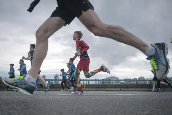  ?? — THE CANADIAN PRESS ?? Some of the nearly 40,000 runners taking part in Sunday’s 33rd Annual Sun Run cross the Cambie Bridge.