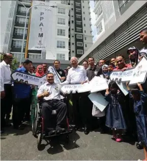  ?? PIC BY MOHD FADLI HAMZAH ?? Prime Minister Datuk Seri Najib Razak in a group photo with new home owners of the Selasih 1Malaysia Civil Servants Housing Project in Putrajaya yesterday. With them are Chief Secretary to the Government Tan Sri Dr Ali Hamsa (left), Federal Territorie­s...