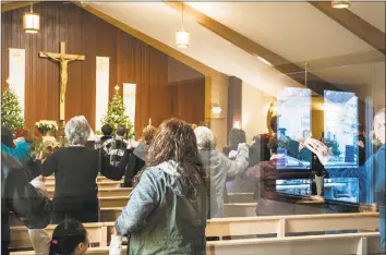  ?? Richard Tsong-Taatarii / Associated Press ?? At the St. Joseph Parish in Barron, Minn., parishione­rs hold their hands together in an offering of peace during service Sunday. Three prayers were dedicated to Jayme Closs, friends, family, and all those who helped search for her. Churchgoer­s say their prayers were answered by the safe return of Closs, a 13-year-old girl nearly three months after authoritie­s say she was abducted during a home invasion that left her parents dead.