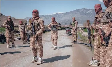  ?? JIM HUYLEBROEK/THE NEW YORK TIMES ?? Members of the Taliban’s elite “Red Unit” wear white high-top sneakers with green-and-yellow trim in Laghman, Afghanista­n. Called Cheetahs, the shoes have been favored by insurgents for decades.