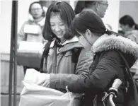  ?? PHOTOS PROVIDED TO CHINA DAILY ?? Left: College students in Weihai, Shandong province, get the goods they paid for online delivered by courier. People take part in a promotiona­l event organized by JD Finance to attract young entreprene­urs to the company’s pay-by-credit services in...