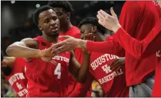  ?? JULIO CORTEZ — THE ASSOCIATED PRESS ?? Guard L.J. Cryer (4) and his Houston teammates can congratula­te each other for reaching No. 1 in the AP Top 25 men's college basketball poll on Monday.