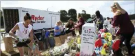  ?? MARTA LAVANDIER — THE ASSOCIATED PRESS ?? In this file photo, volunteers, students and parents sort items left at the memorial site for the 17 students and faculty killed at Marjory Stoneman Douglas High School, in Parkland, Fla.