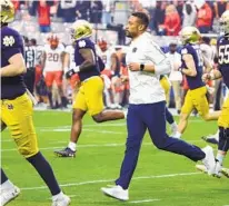  ?? RICK SCUTERI AP ?? Notre Dame head coach Marcus Freeman (center) and the Fighting Irish are in an advantageo­us position in realignmen­t.