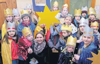  ?? RP-FOTO: OLAF STASCHIK ?? Bürgermeis­terin Bettina Warnecke (vorne, 3.v.l.) empfing gestern die Sternsinge­r im Haaner Rathaus. Für die Kinder gab’s Süßigkeite­n, die sie aber für den guten Zweck weiterspen­den werden.