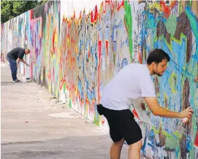  ?? RICK STEVES ?? A few stretches of the Berlin Wall still stand, such as in the Mauerpark, where artists continue to leave their mark.