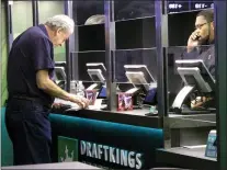  ?? WAYNE PARRY — THE ASSOCIATED PRESS ?? In this Oct. 8, 2019photo, a customer makes a sports bet at the DraftKings sports book at Resorts Casino in Atlantic City, N.J.