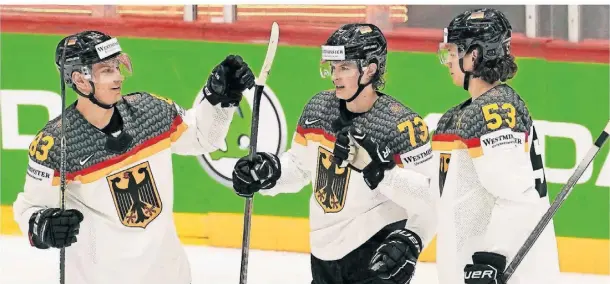  ?? FOTO: MARTIN MEISSNER/AP ?? Lukas Reichel (Mitte) traf für Deutschlan­d zum 4:2 und wird von seinen Teamkolleg­en beglückwün­scht.