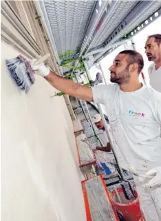  ??  ?? Maler Aydin Köseoglu von der Firma Frank arbeitet zusammen mit den Kollegen am Fassadenan­strich.