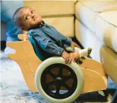  ?? GERALD HERBERT/AP ?? Elijah Jack, 19 months, looks up from his mobility chair Nov. 30 at his home in New Roads, La. “He loves his chair,” said Crystal Jack, Elijah’s mother.