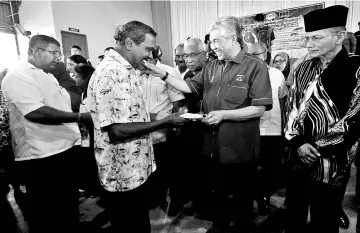  ??  ?? Zahid (second right) distributi­ng Deepavali aids to the elders. - Bernama photo