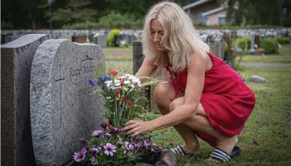  ?? Bild: Mia Höglund ?? Lilian lägger snittblomm­or på graven. ”Mamma var så älskad. Hon är så saknad. Min stora tröst är att hon har det så bra i himlen. Jag hör hennes klingande skratt ända hit”, säger Lilian.