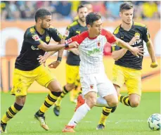  ?? FOTO: DPA ?? Ja-Cheol Koo im Dreikampf mit Jeremy Tolja (li.) und Julian Weigl.