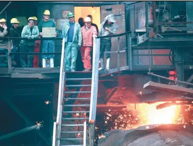  ?? MORNING CALL FILE PHOTO ?? Workers from the last shift of Bethlehem Steel’s Blast Furnace gather on the furnace’s landing as the final molten iron pours into a submarine rail car November 18th, 1995. For the first time since 1873, steel would not be made in the Lehigh Valley.