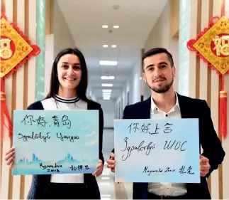  ??  ?? Dos hermanos rusos, ambos estudiante­s de la Universida­d del Petróleo de China en Qingdao, escriben en ruso y en chino un mensaje de bienvenida a la Cumbre de la OCS que se realizará este mes de junio.