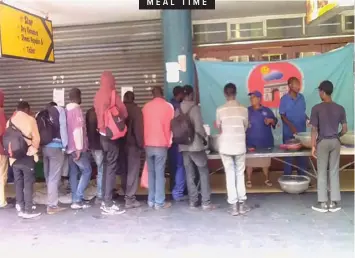  ??  ?? HOMELESS people line up for a New Year’s Eve lunch at Poynton’s Building in the Pretoria CBD.