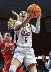  ?? Jessica Hill/Associated Press ?? UConn’s Paige Bueckers (5) shoots while defended by Syracuse’s Georgia Woolley on Monday night in Storrs.