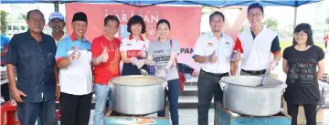  ??  ?? Ling (second right) and his Democratic Action Party (DAP) Sibu team join volunteers to distribute ‘bubur lambuk’ to the public at Sibu Town Square.