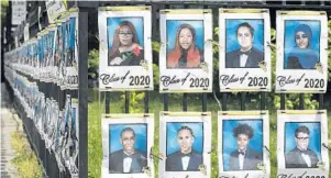  ?? MARK LENNIHAN/AP ?? Photograph­s of the graduating class of 2020 line the fence in front of James Madison High School on May 27 in the Brooklyn borough of New York.