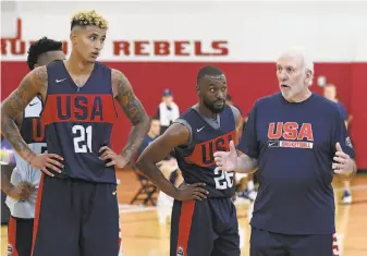  ?? Ethan Miller / Getty Images ?? U.S. head coach Gregg Popovich (right) talks with Kyle Kuzma (21) and Kemba Walker during a practice session in Las Vegas. Popovich has replaced Mike Krzyzewski.