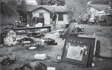  ?? .JOSH HANER / THE NEW YORK TIMES ?? Bruce Hooper surveys the flood debris on Oct. 19 outside his home in Kashmere Gardens, a poor neighborho­od in Houston. Hooper said that his family of five had to be airlifted out during Hurricane Harvey after a detention pond overflowed and water inside the house rose from ankle to chest high in an hour. Like many others without f lood insurance or savings, he said they had nowhere else to go.