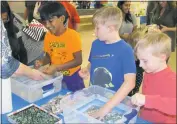  ??  ?? Children make makeshift boats from aluminum foil and test how many marbles they can add before it sinks.