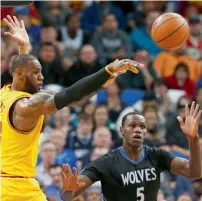  ?? AP ?? LeBron James gets off a pass as Minnesota Timberwolv­es’ KarlAnthon­y Towns defends. —