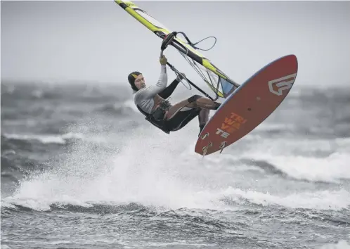 ??  ?? Windsurfer­s make the most of the stormy condition sat Barassie Beach at Troon in South Ayrshire