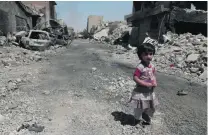 ?? Florian Neuhof for The National ?? A little girl falls behind as her family leaves the heavily bombed out Shifaa neighbourh­ood in Mosul.