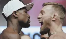  ?? AP PHOTO ?? A LABOR OF GLOVE: Floyd Mayweather Jr. (left) and Conor McGregor come face to face yesterday during weigh-ins for their boxing match tonight in Las Vegas.