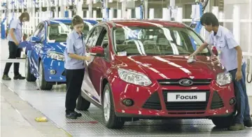  ??  ?? Operators at a Ford plant in Thailand put the finishing touches on the maker’s 350 millionth Focus.