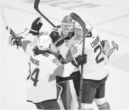  ?? CRAIG LASSIG AP ?? Panthers goalie Sergei Bobrovsky is embraced by teammates Nick Cousins and Ryan Lomberg after defeating the Minnesota Wild in a shootout on Monday.