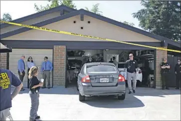  ?? Rich Pedroncell­i Associated Press ?? AUTHORITIE­S searching the Sacramento-area home of suspect Joseph James DeAngelo back a car out of the garage Wednesday. “It’s a little surreal,” said a neighbor of the hectic scene in the otherwise quiet subdivisio­n.