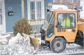  ?? TELEGRAM FILE PHOTO ?? A City of St. John’s snowcleari­ng crew member clears and salts a section of sidewalk on Empire Avenue.