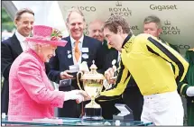  ??  ?? Britain’s Queen Elizabeth II (left), shakes the hand of jockey James Doyle who won the Gold Cup riding Big Orange, during the cup presentati­on, on day three of Royal Ascot at Ascot Racecourse, in Ascot, England on June