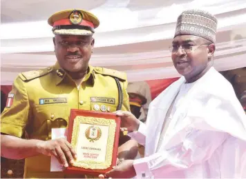  ?? ?? Chairman and Chief Executive of National Drug Law Enforcemen­t Agency ( NDLEA), Brig- Gen Mohammed Marwa ( right), presenting award of excellence to the Commander, NDLEA Lagos Command, Abubakar Wali, in recognitio­n of outstandin­g performanc­e in supply reduction, during the Chairman’s Excellence Award, in Abuja… yesterday.
