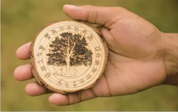  ?? ?? An emblem created by a soldier for the group of Fort Eustis soldiers who come to the Elmerton and Bassett cemeteries every other Saturday to cut grass, rake, clean headstones and clear brush. The emblem reads “Unity Through Community” and features an oak tree with educator Mary Peake, who is buried in Elmerton Cemetery.