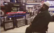  ??  ?? A Palestinia­n man watches a televised broadcast of the UN General Assembly vote