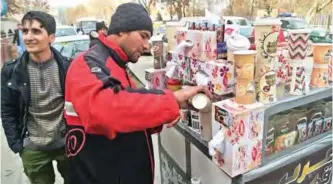  ??  ?? Najibullah Sharyari (center), 30, prepares coffee for customers at his cart in Kabul. — AFP photos